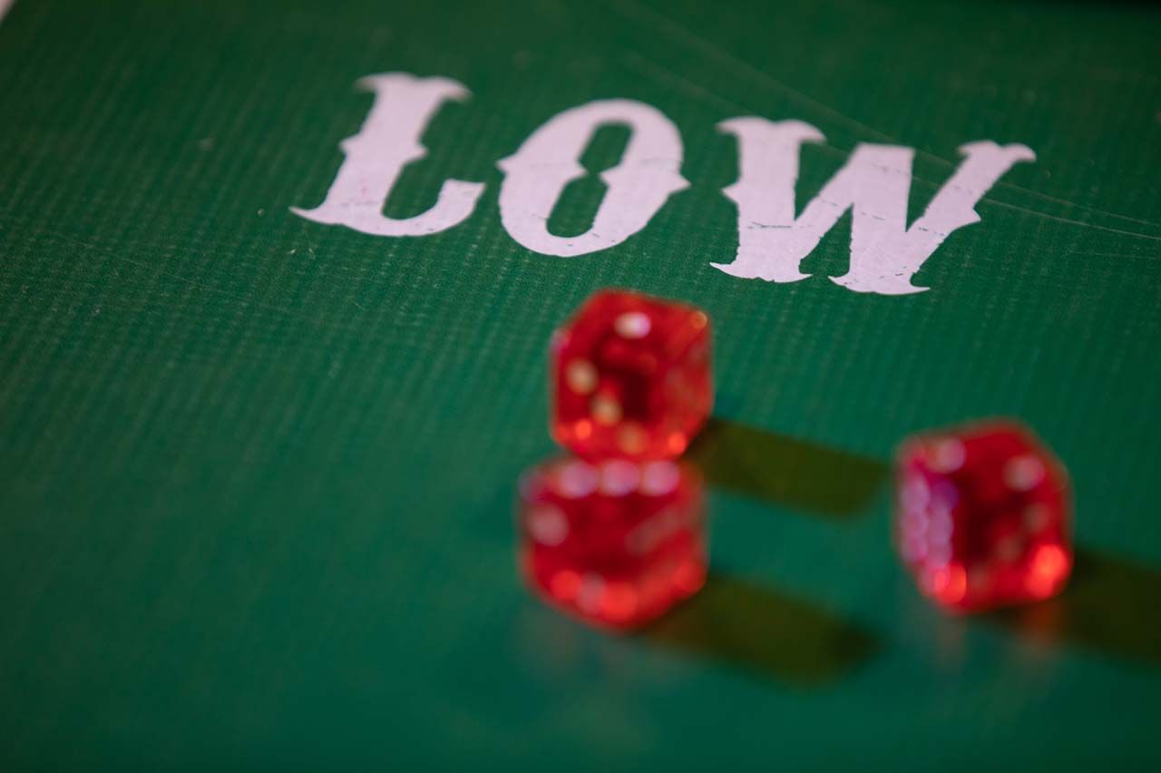 Close up of green poker table with the words LOW and three red die