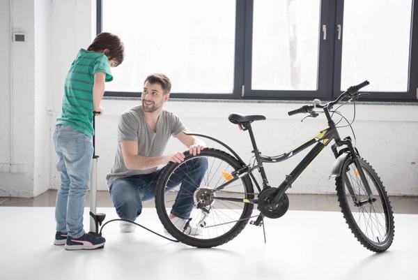 Father and son busy pumping a bike's tires