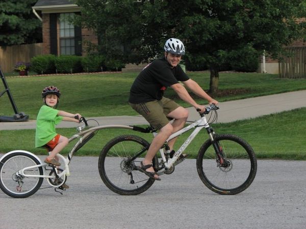 Father and son on a bike tandem attachment
