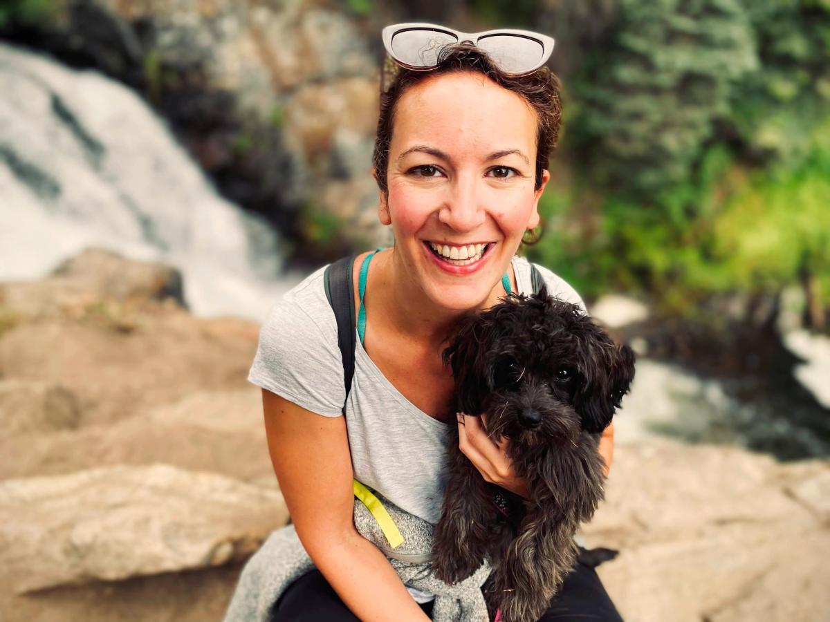 Jessica Weeman with her dog in front of a fall.
