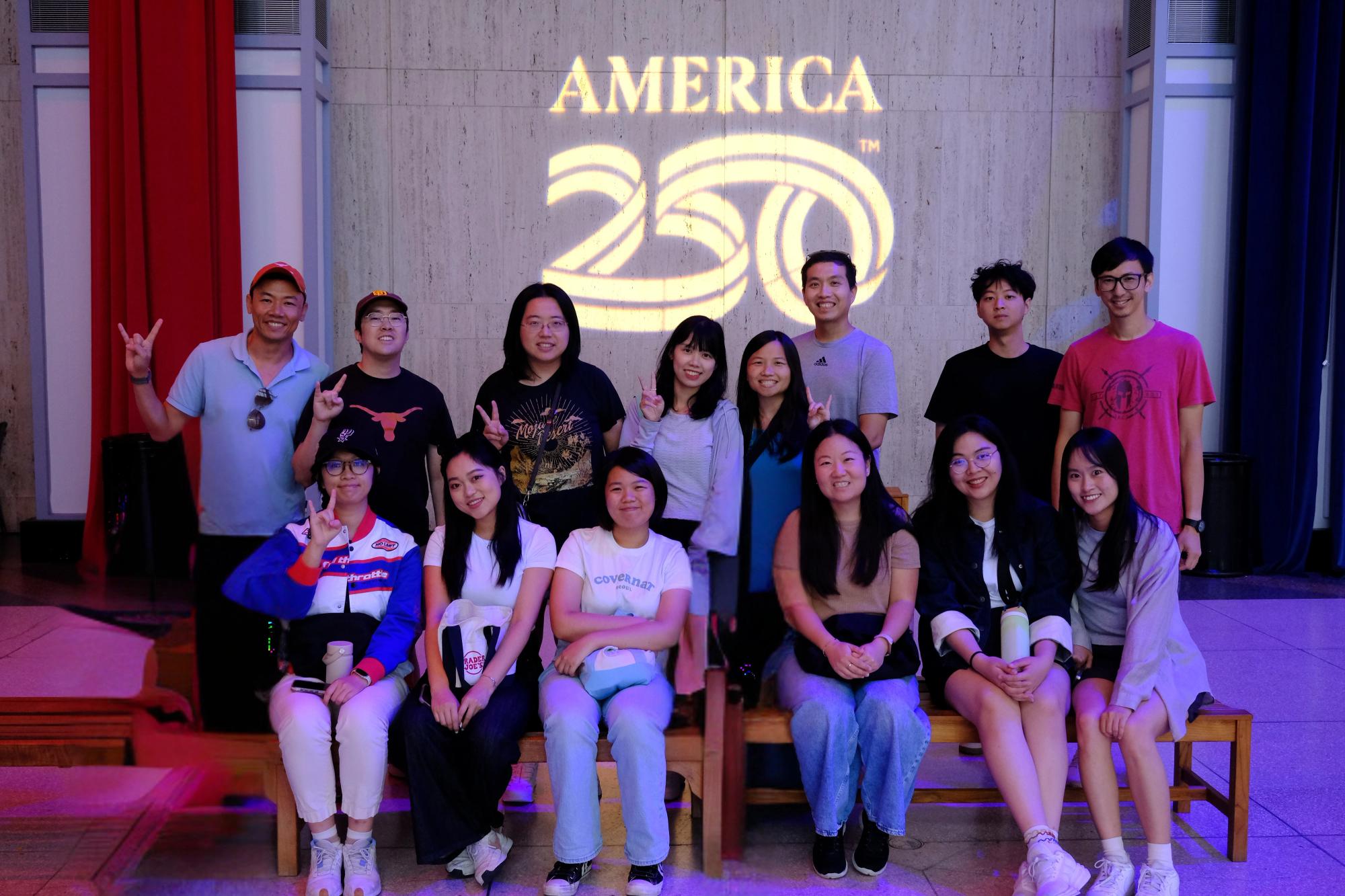 Mentors and students in front of America 250 years anniversary sign.