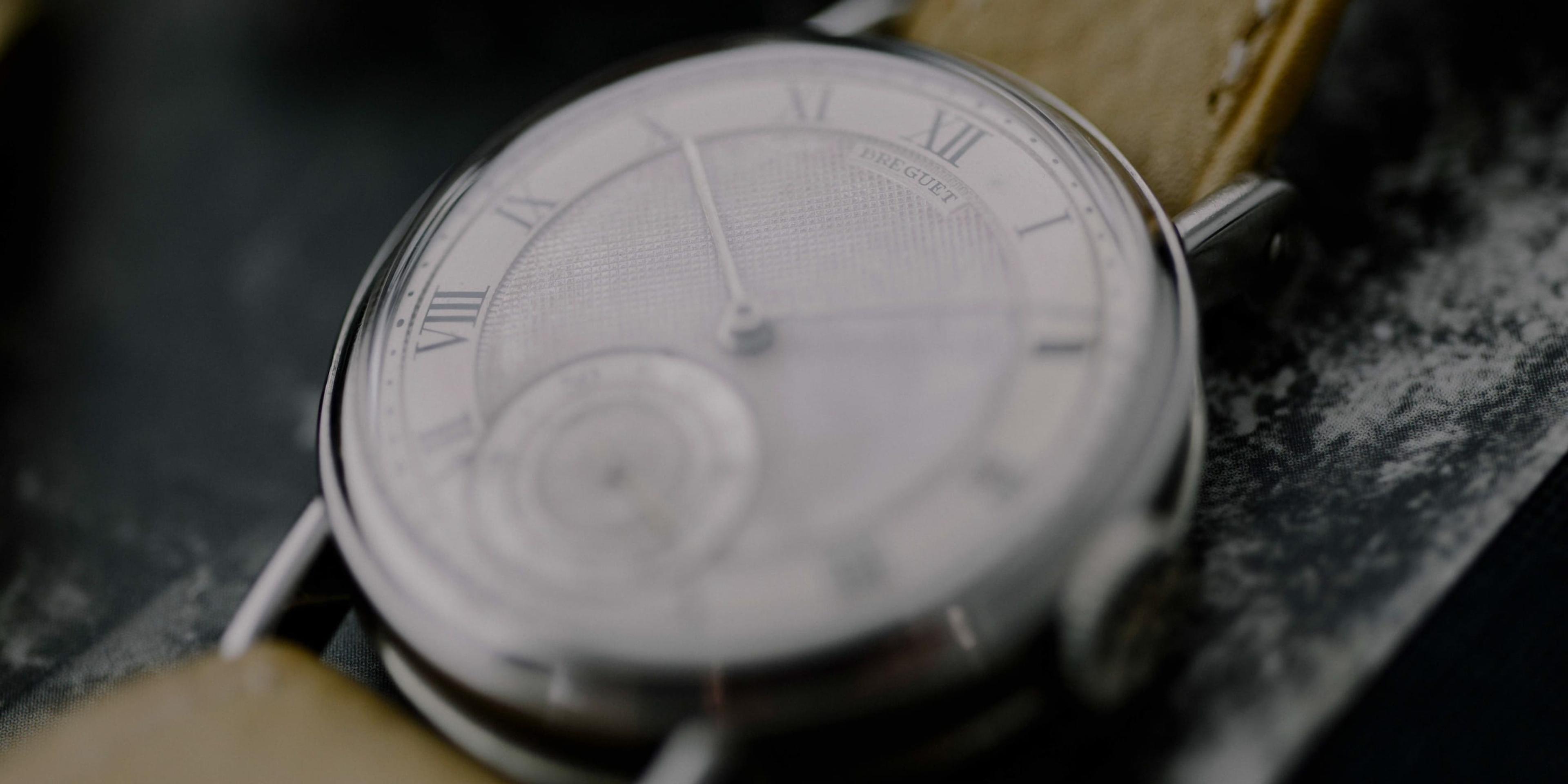 A watch with roman numerals and a leather band