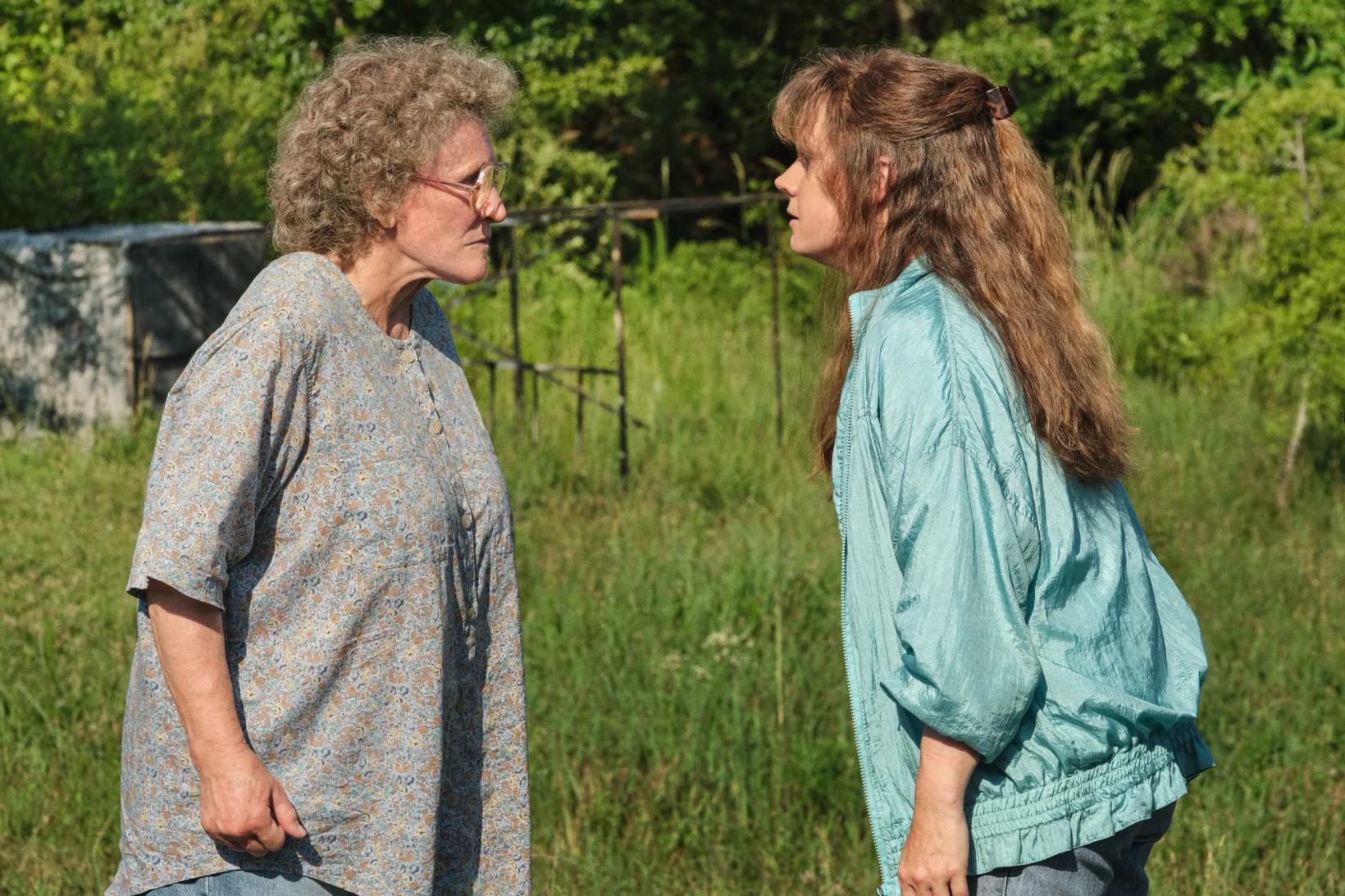 a couple of women walking in a field