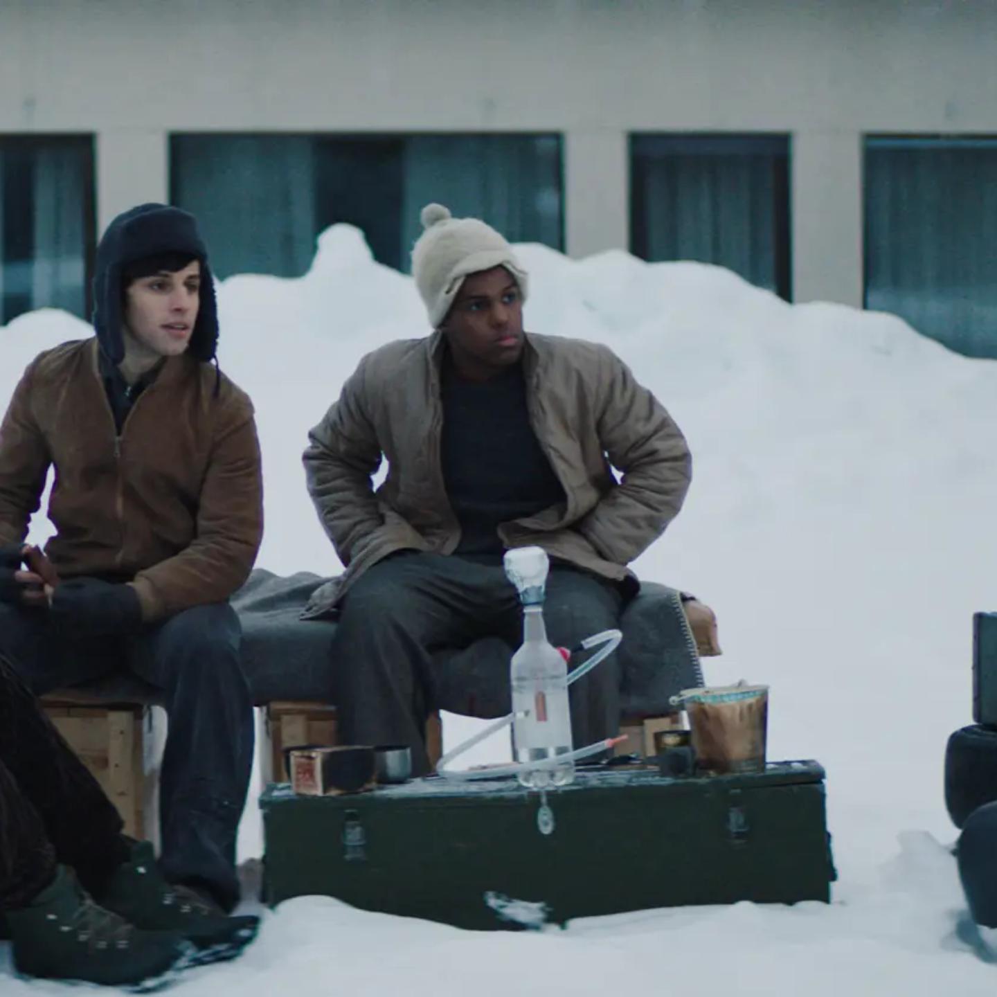 a group of men sitting on a bench in the snow