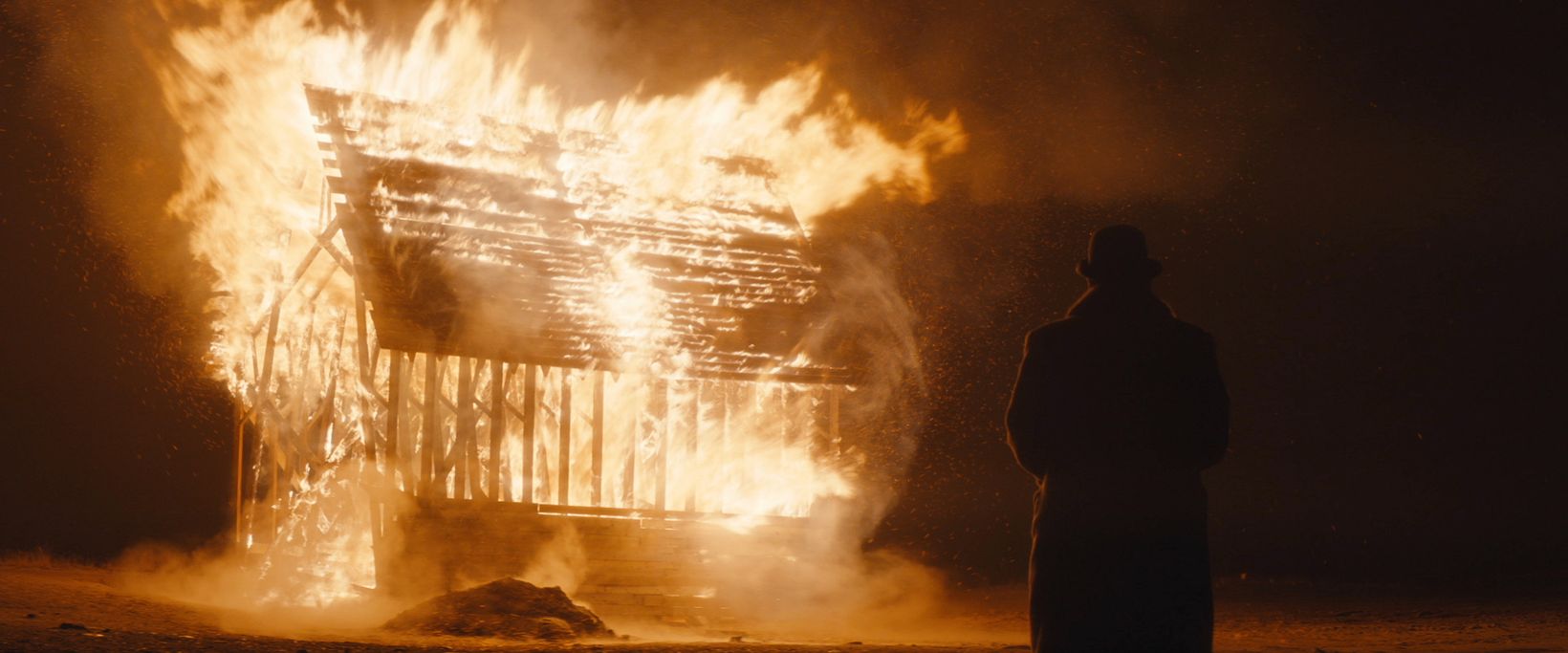 a person standing in front of a large explosion