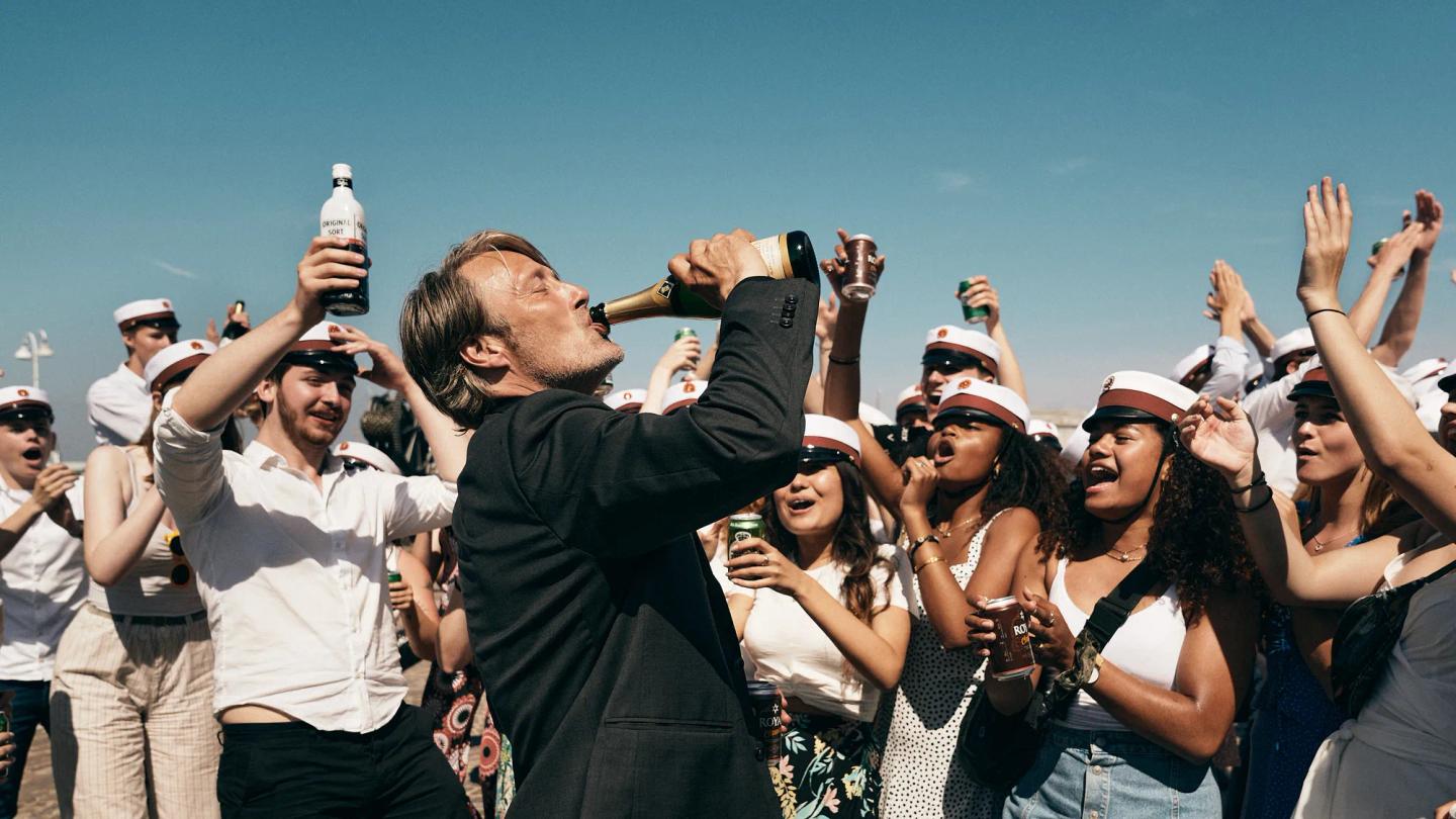 a woman holding a bottle of alcohol in front of a crowd of people