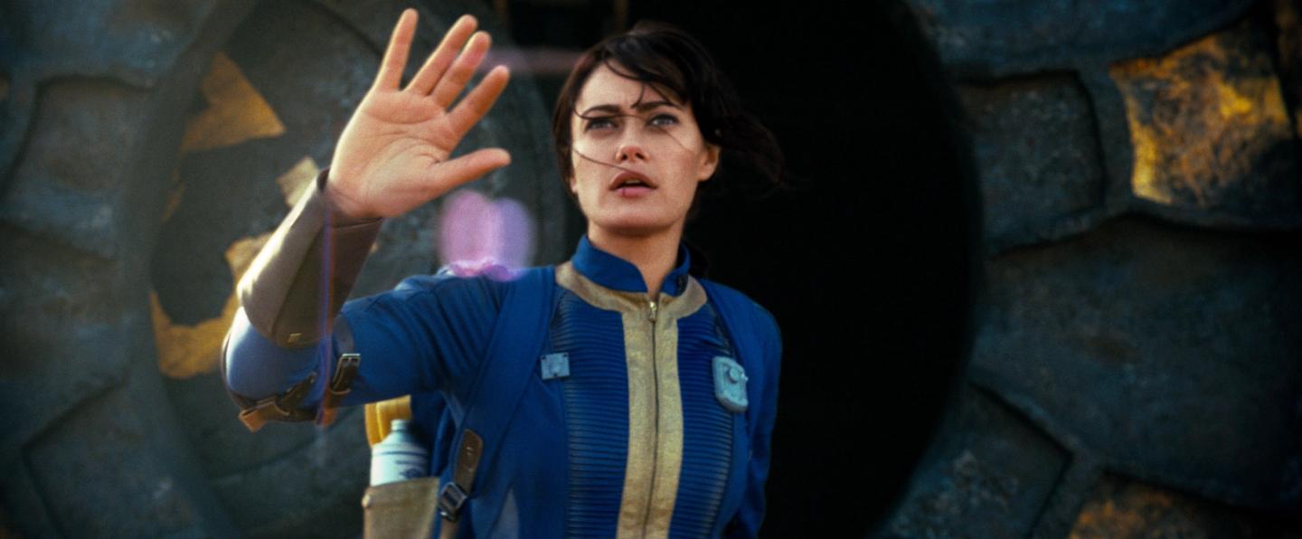 Ella Purnell i rollen som Lucy holder armen foran seg i Fallout.