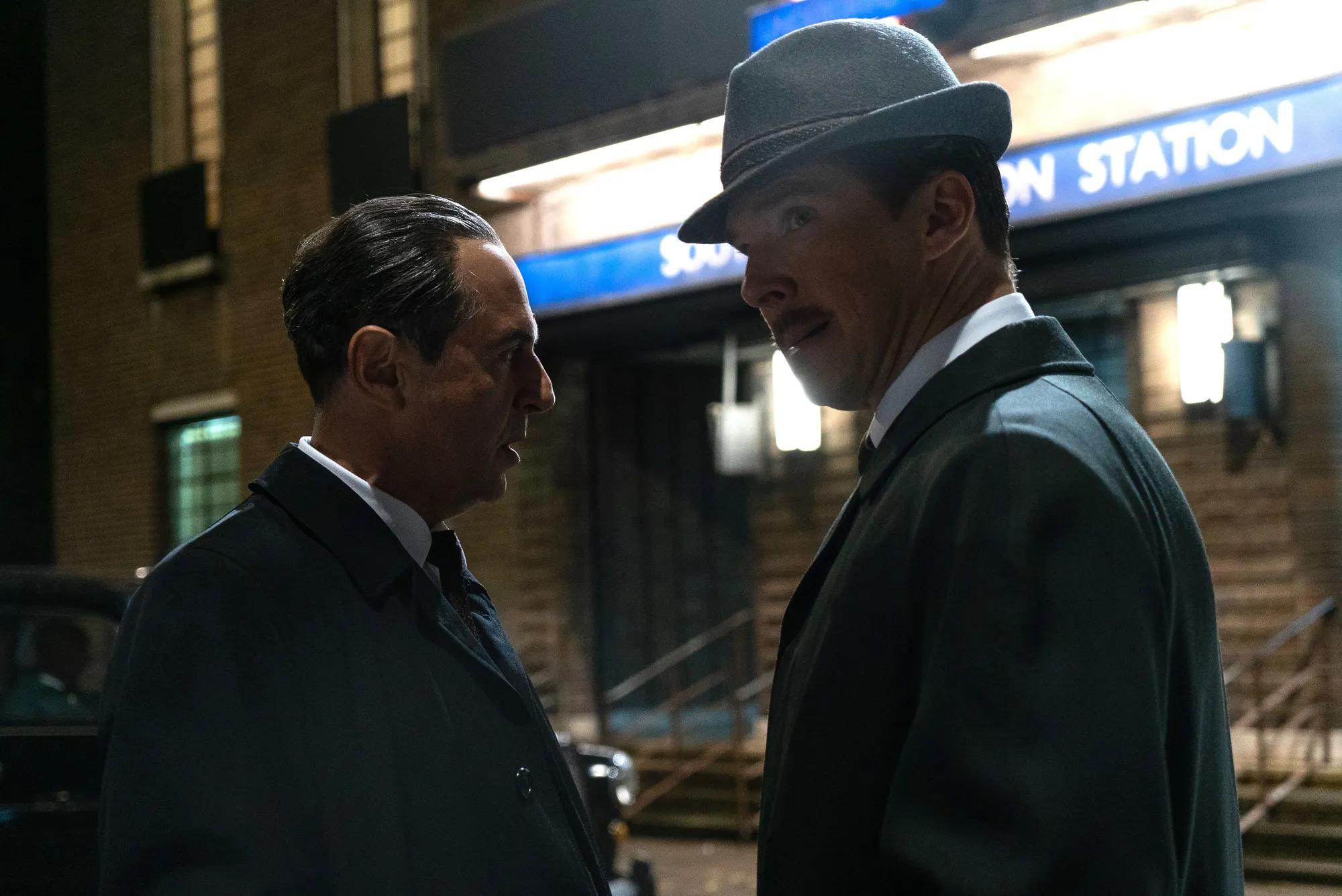 a man in a suit talking to another man in a suit