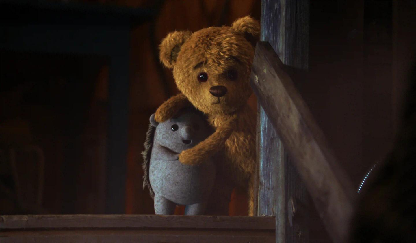 a couple of teddy bears sit on a wooden shelf