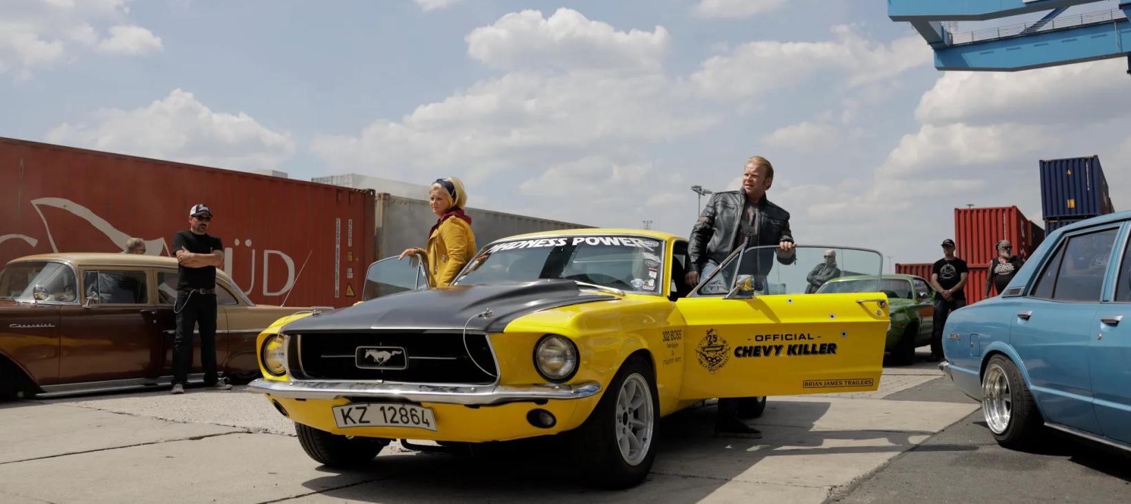 a yellow car with a person standing next to it