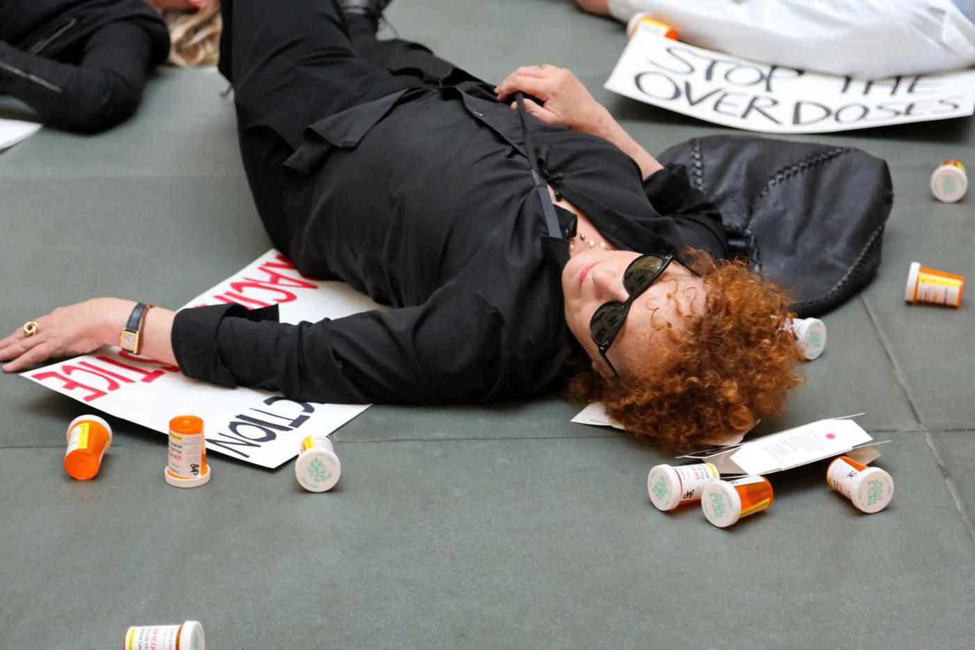 a person lying on the ground with a pile of poker chips and cards