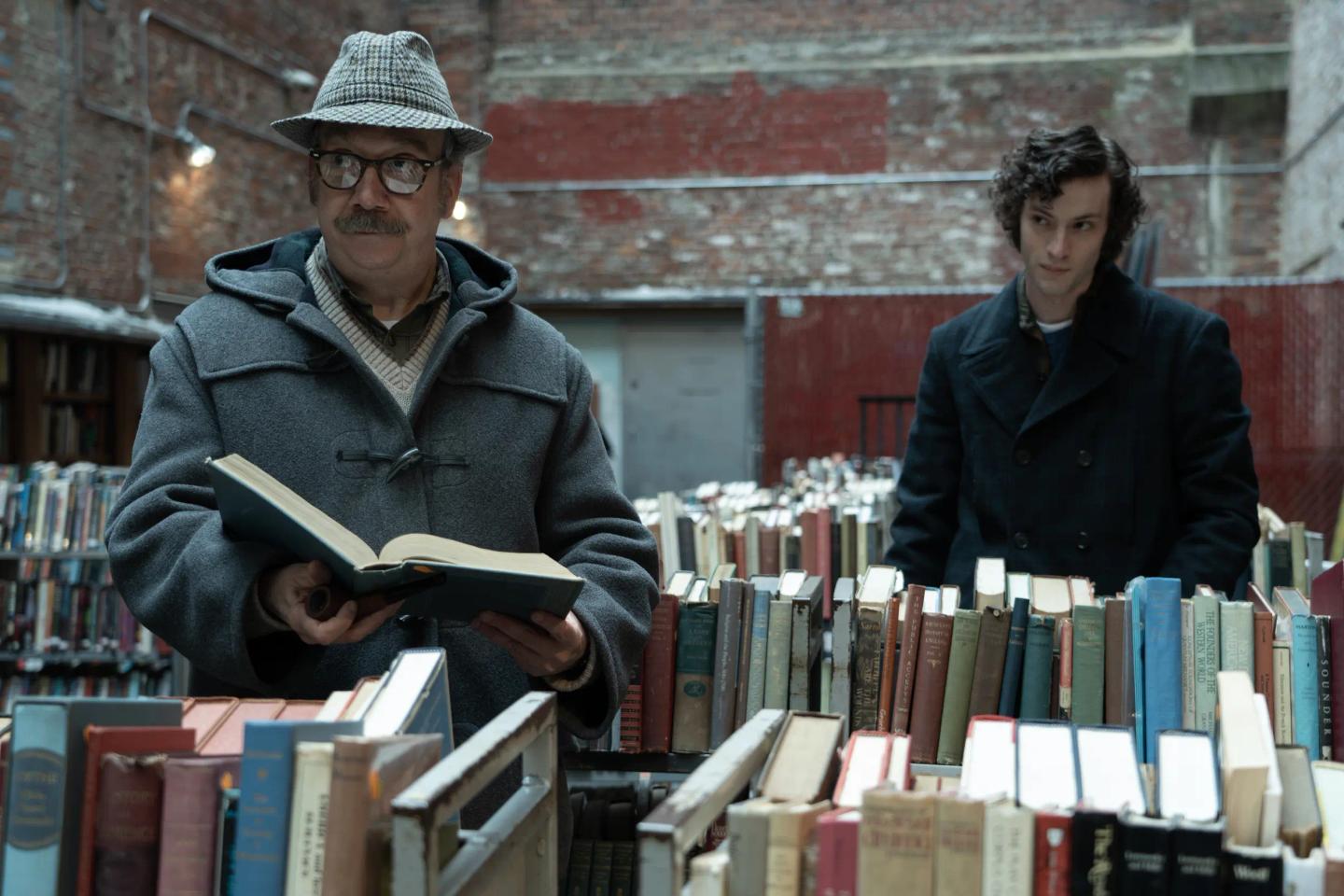 a man and a woman standing next to a shelf of books