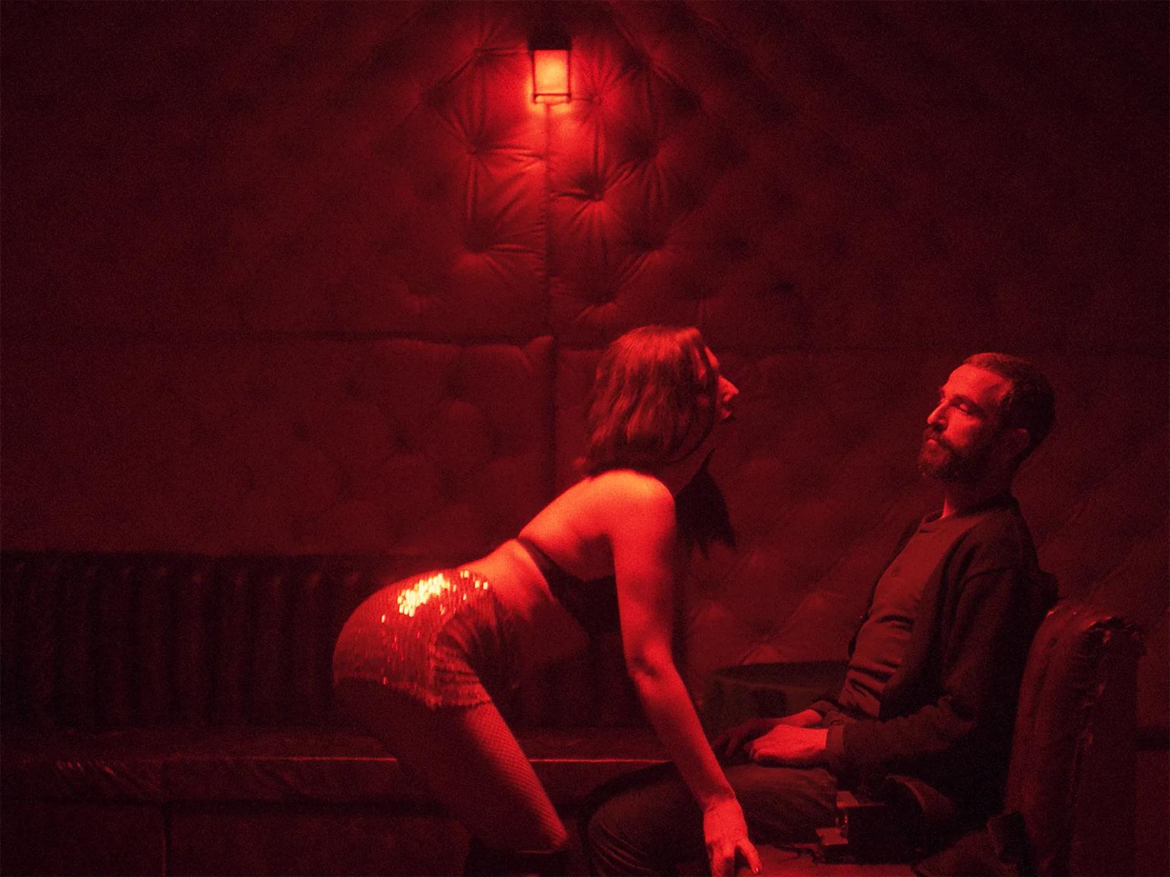 a man and woman sitting on a bench with a fire in the background