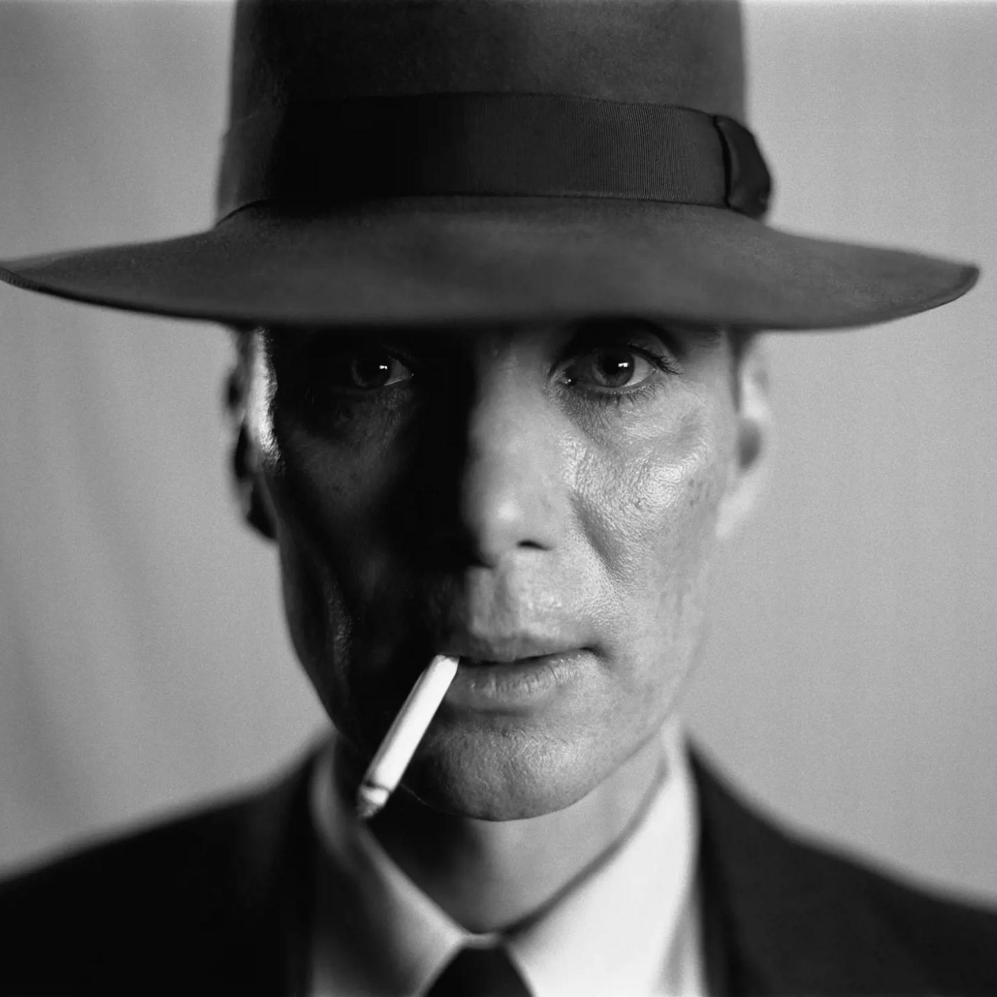 a man wearing a hat and smoking a cigarette