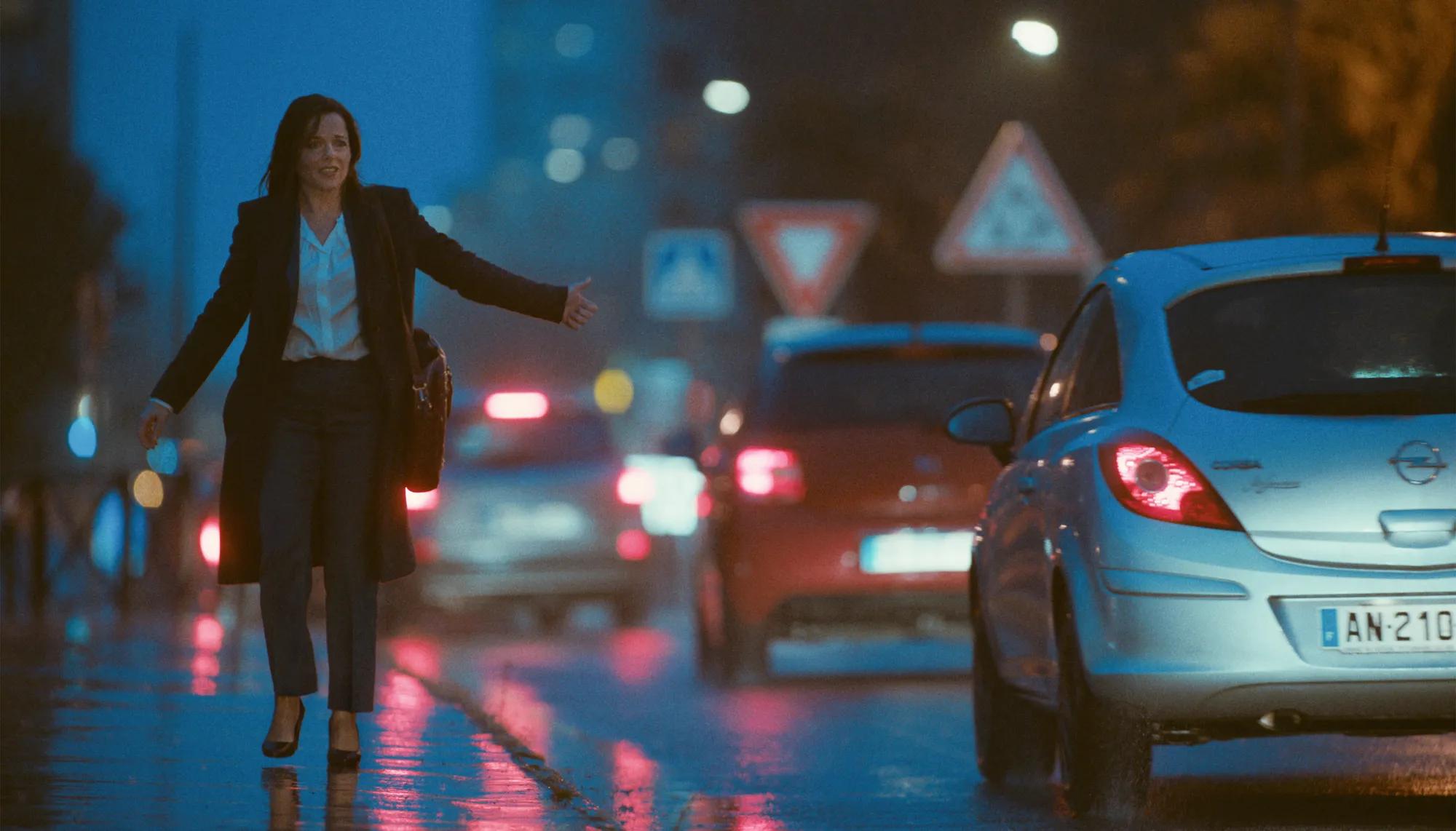 a person in a suit walking on a wet street