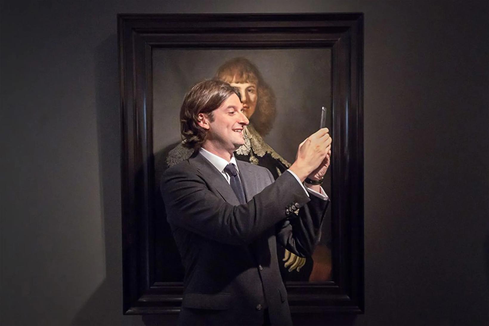 Jan Six holding a pen and a person in a suit