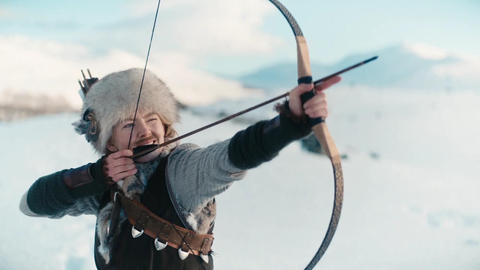 a man in a garment holding a bow and arrow
