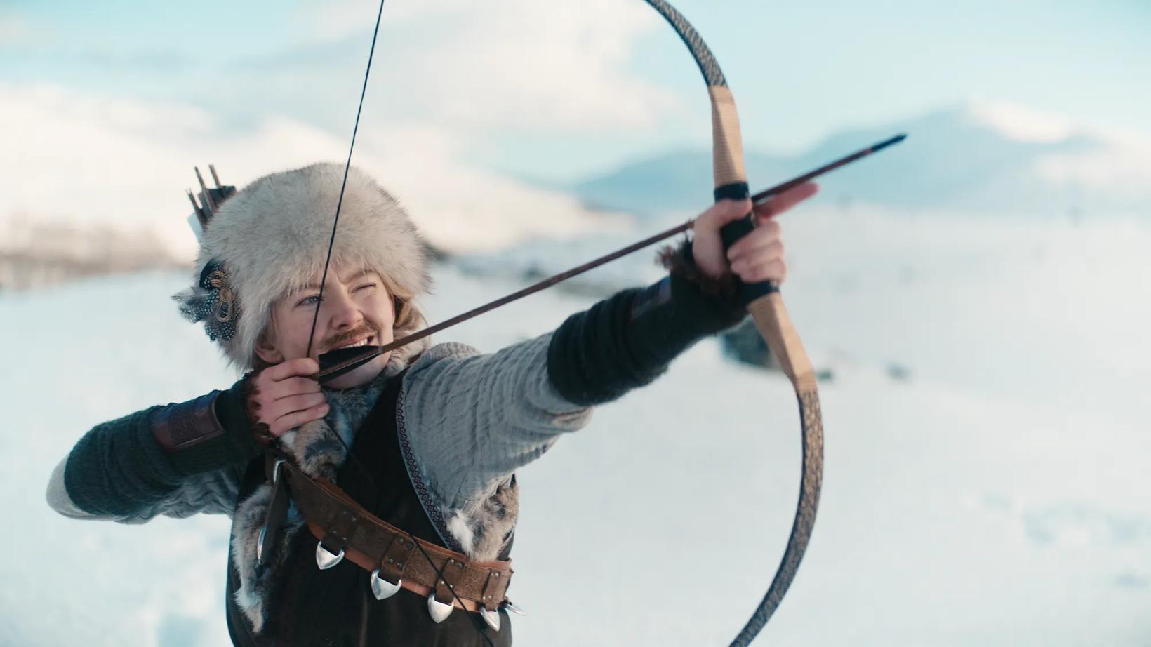 a man in a garment holding a bow and arrow