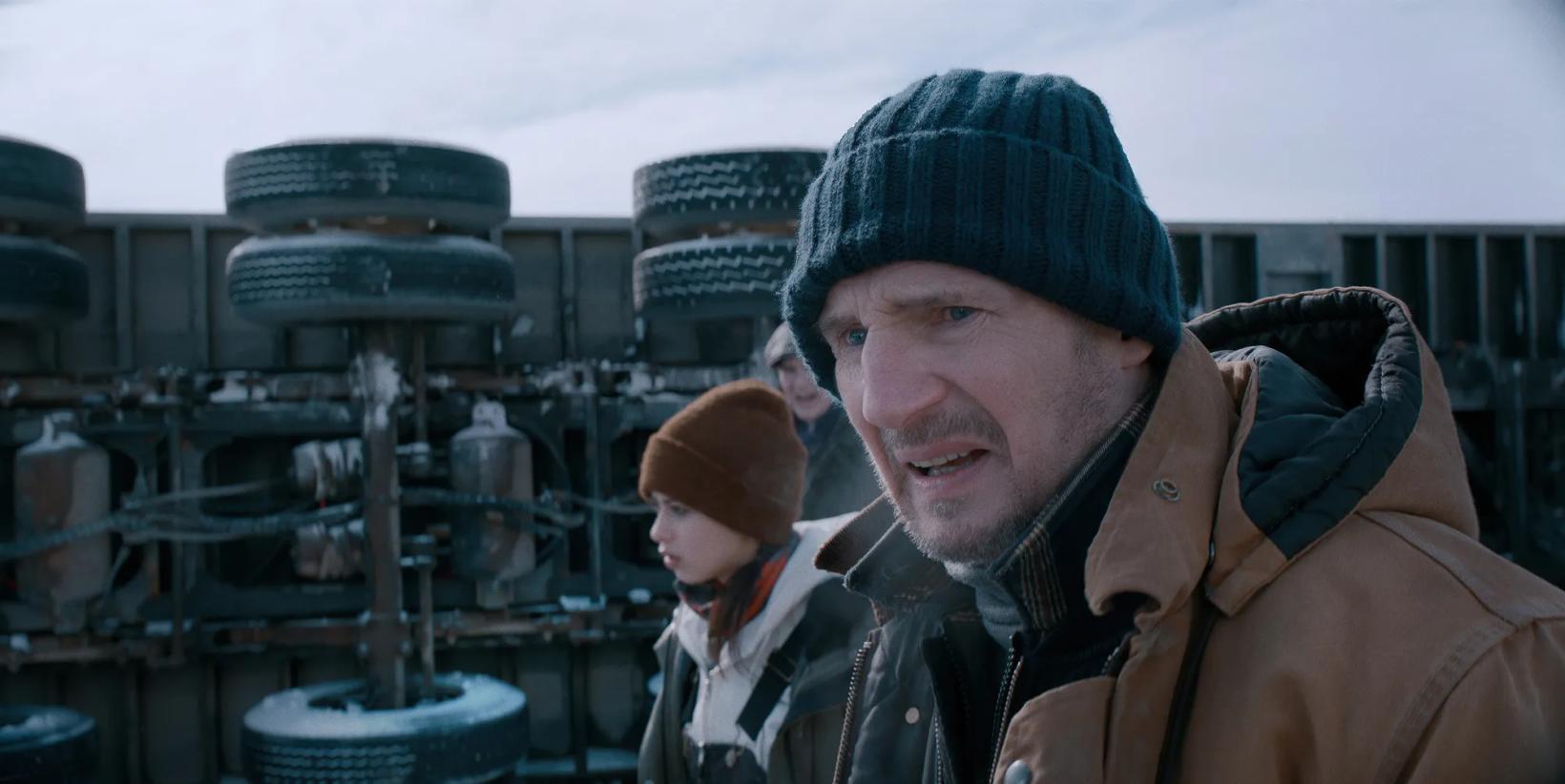 Liam Neeson and woman in a factory