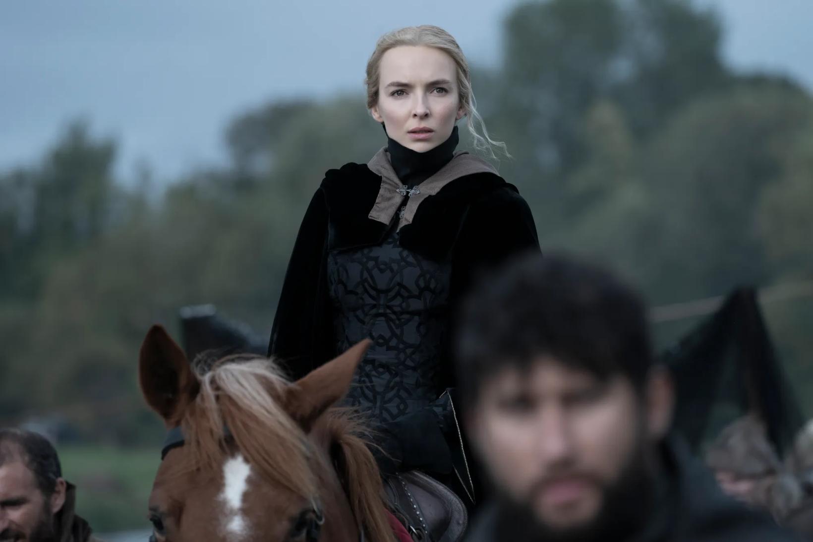 Jodie Comer standing on a horse