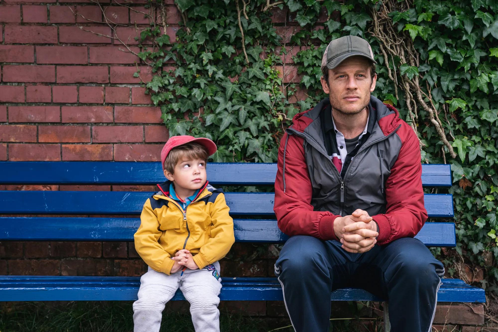 James Norton and a child sitting on a bench