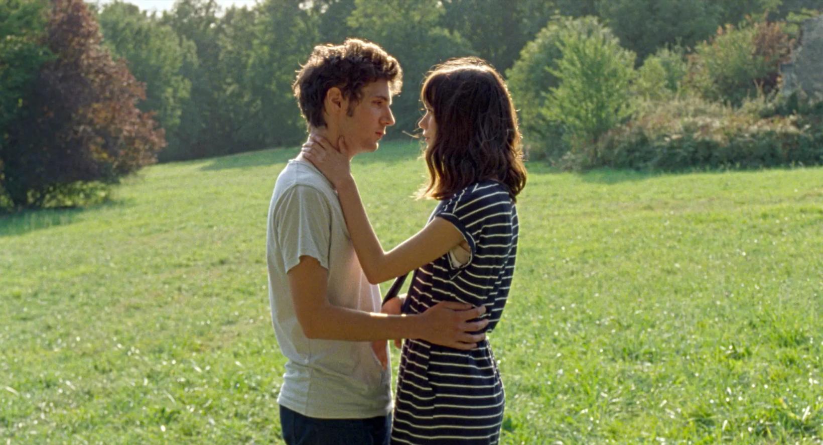 a man and woman hugging in a field