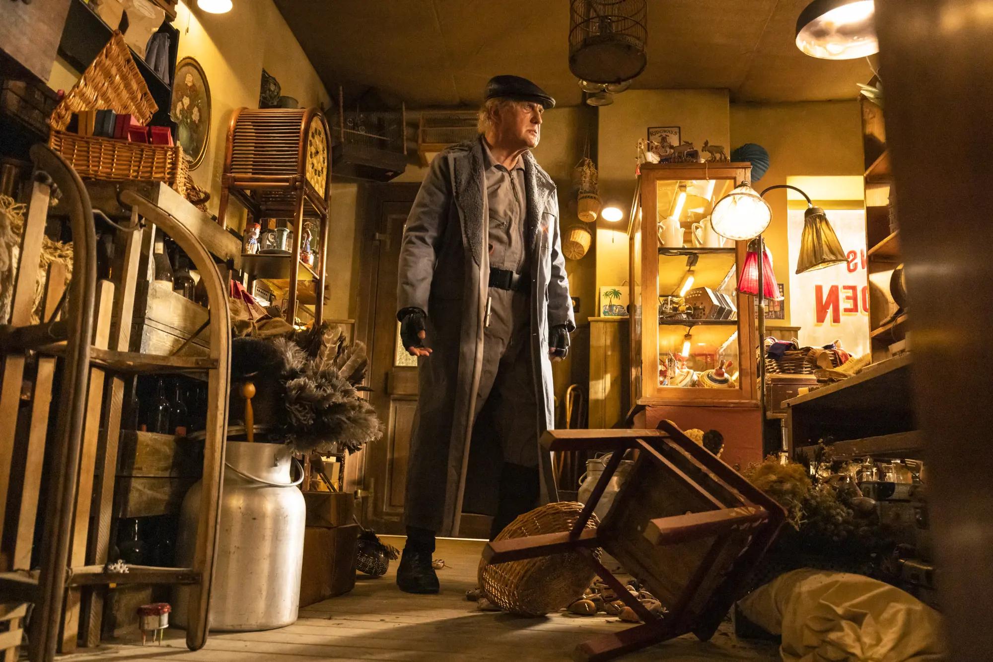 a man in a hat standing in a shop