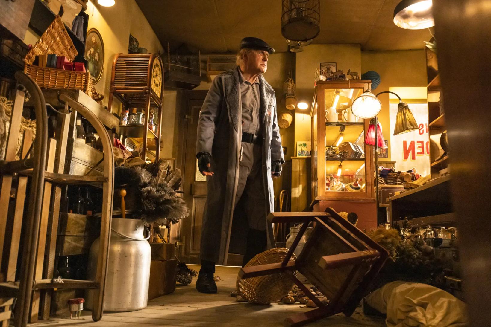 a man in a hat standing in a shop