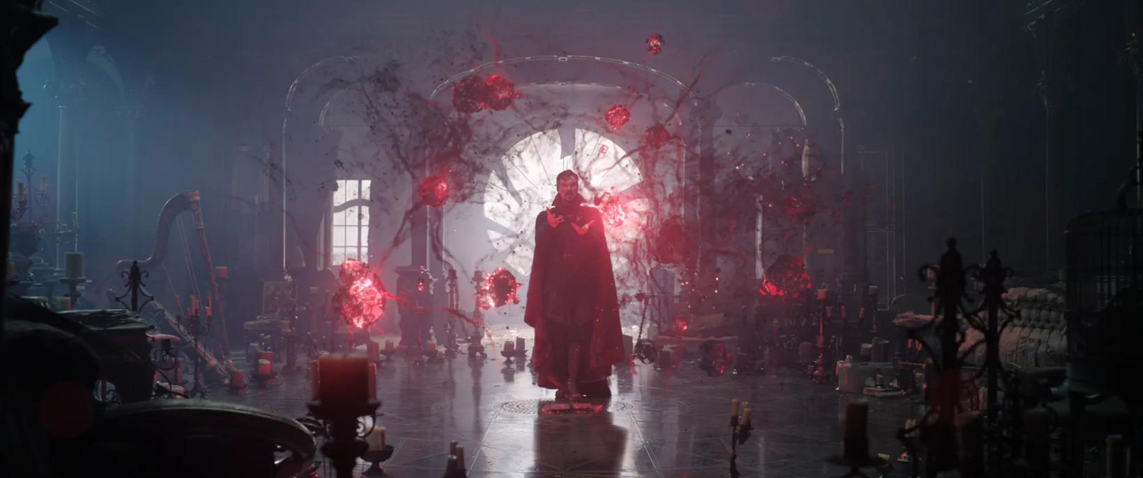 a person in a red robe and hat standing in front of a stage with lights