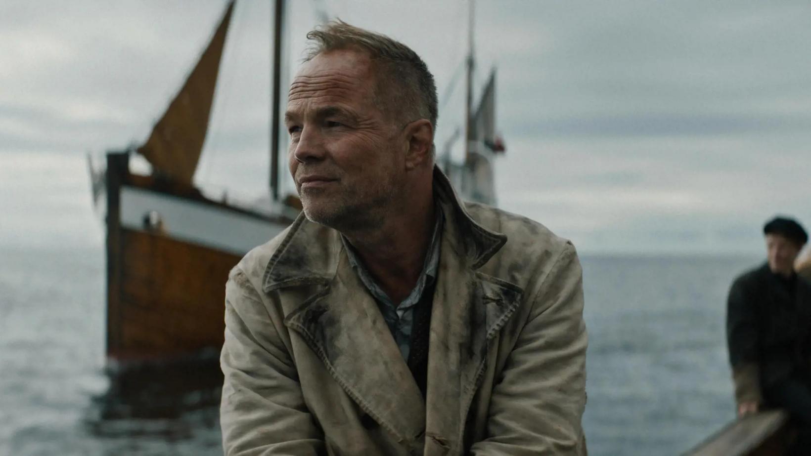 Jon Øigarden standing in front of a boat