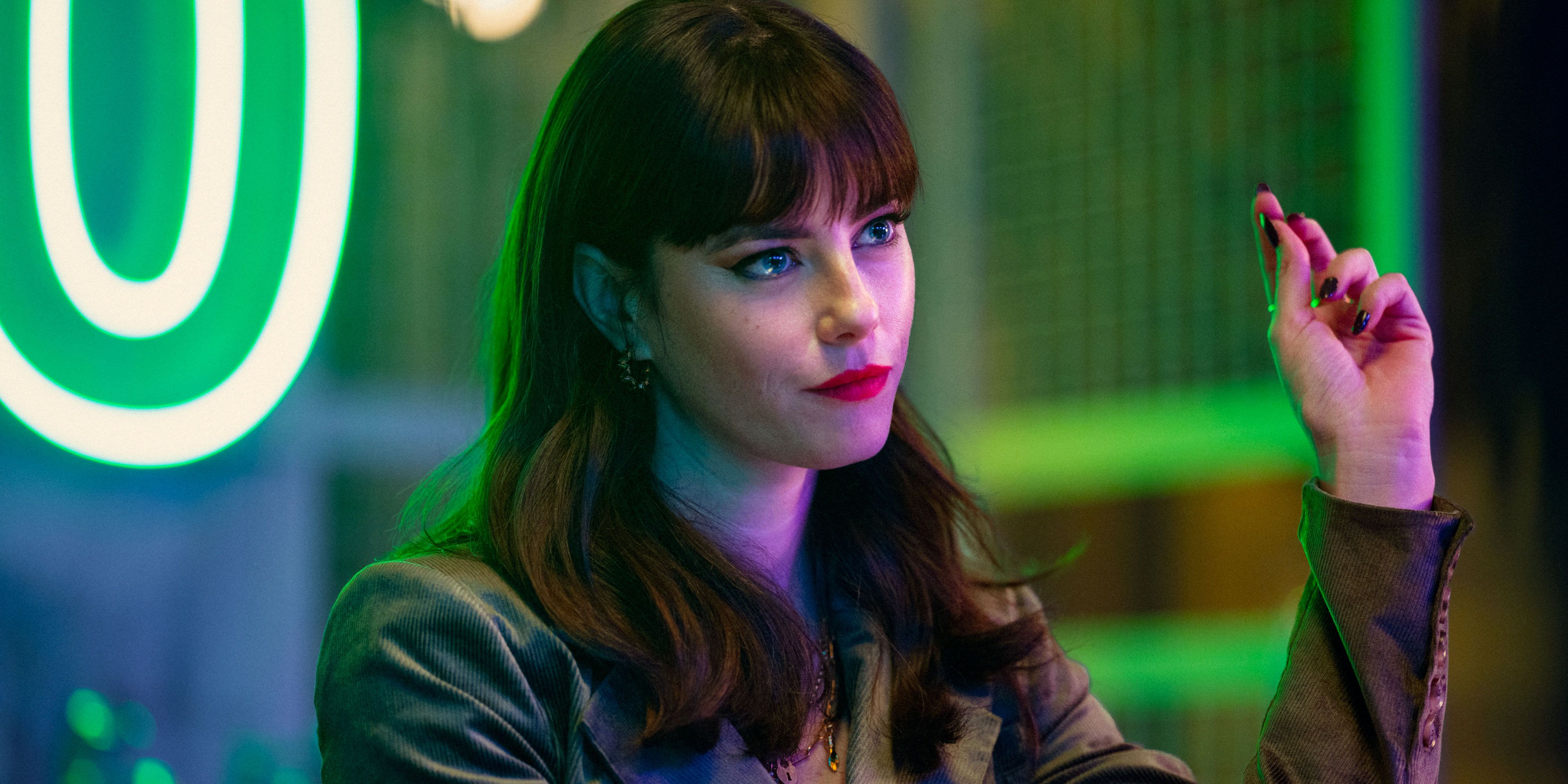 Kaya Scodelario omgitt av neonlys i The Gentlemen (serie, 2024).