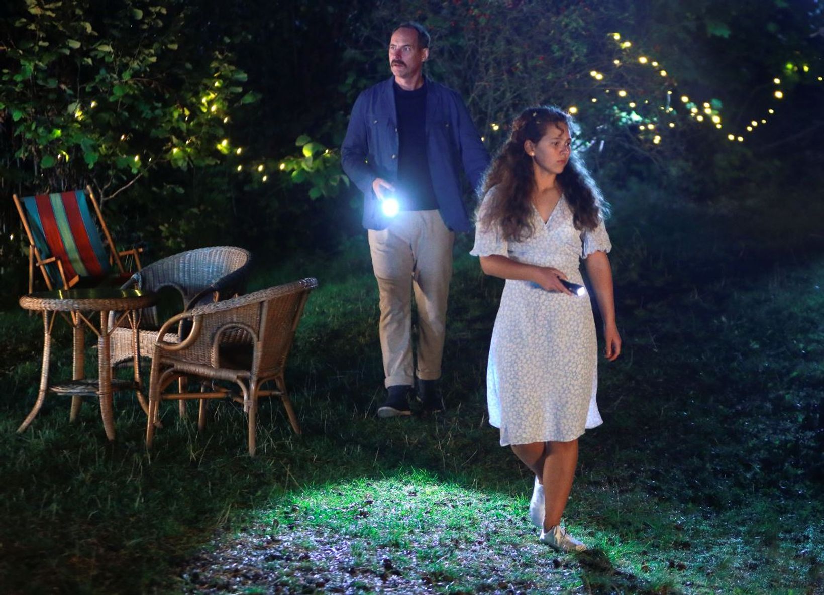a man and woman walking in a backyard
