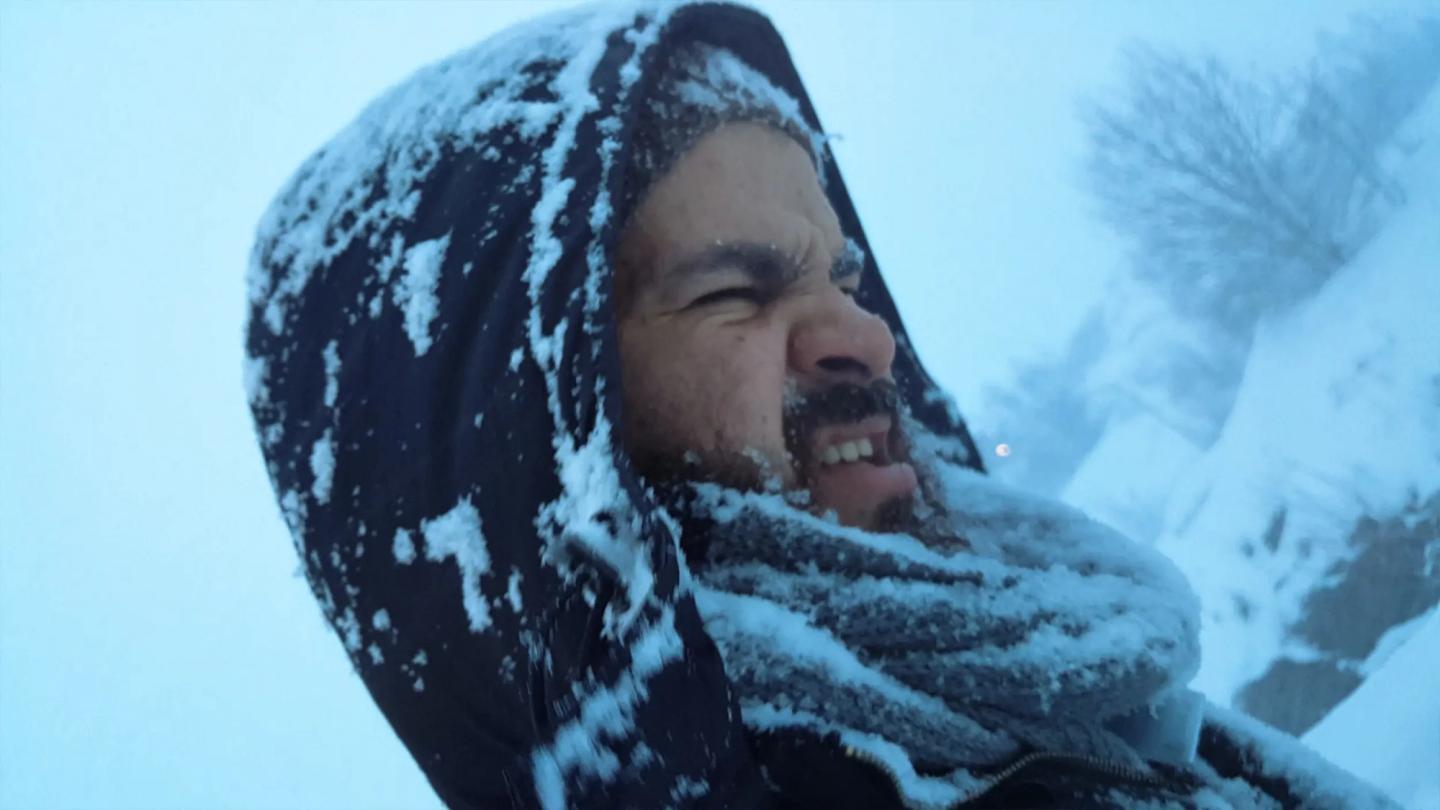 a person wearing a hood and holding a snowball