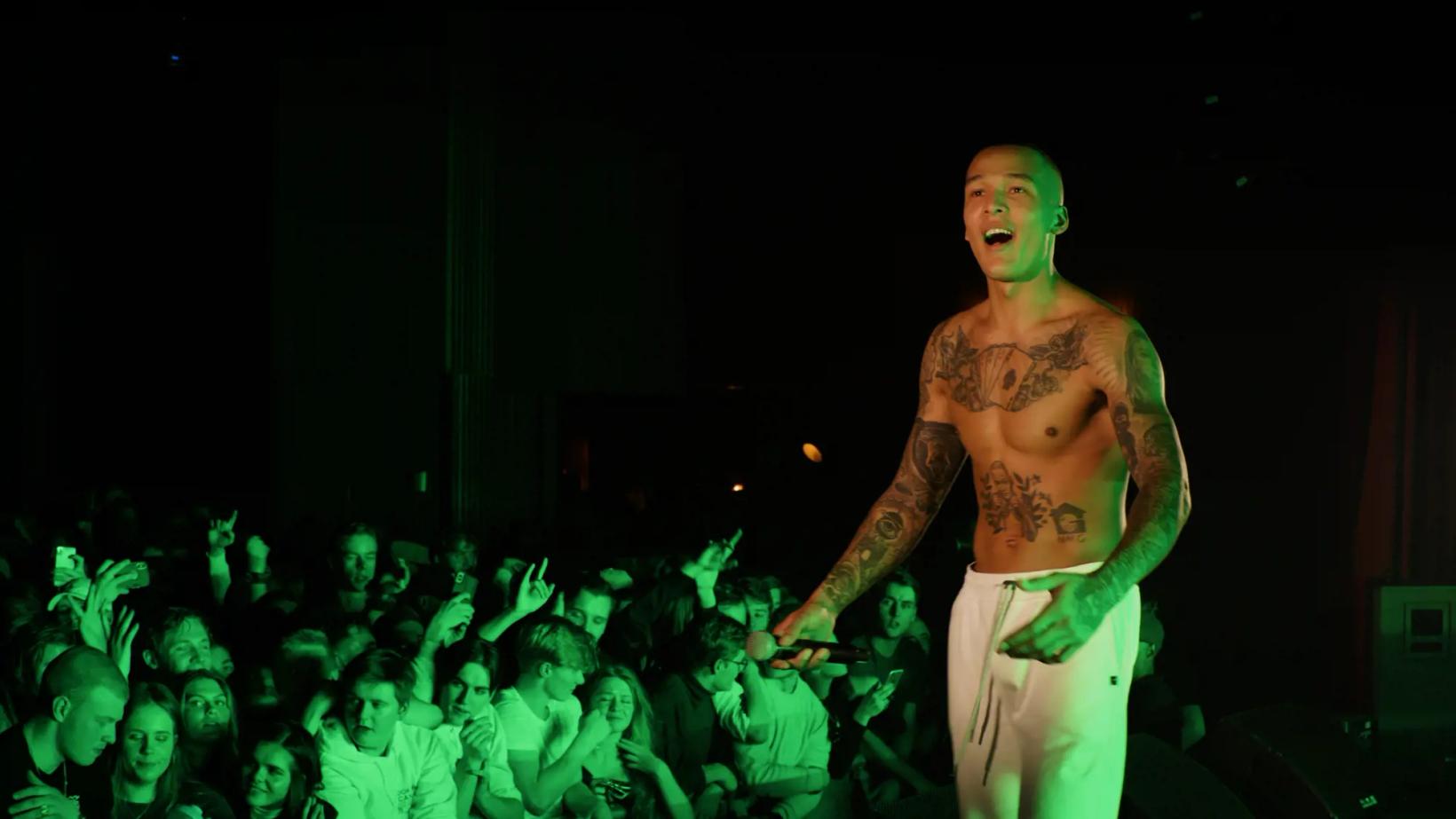 a person with no shirt on in front of a crowd of people
