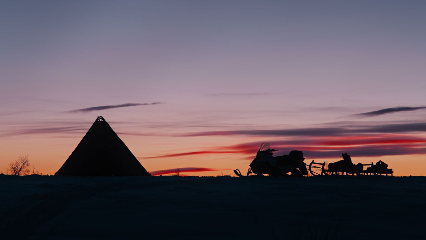 a silhouette of a pyramid and a person on a horse in front of a sunset