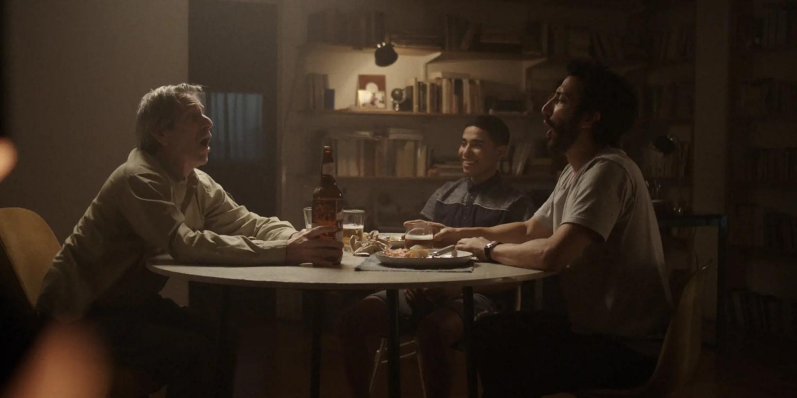 a group of men sitting at a table with food and drinks