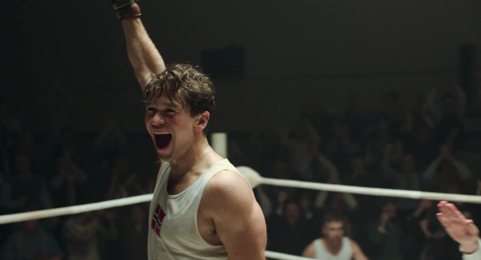 a person in a white tank top with the arms raised in a ring