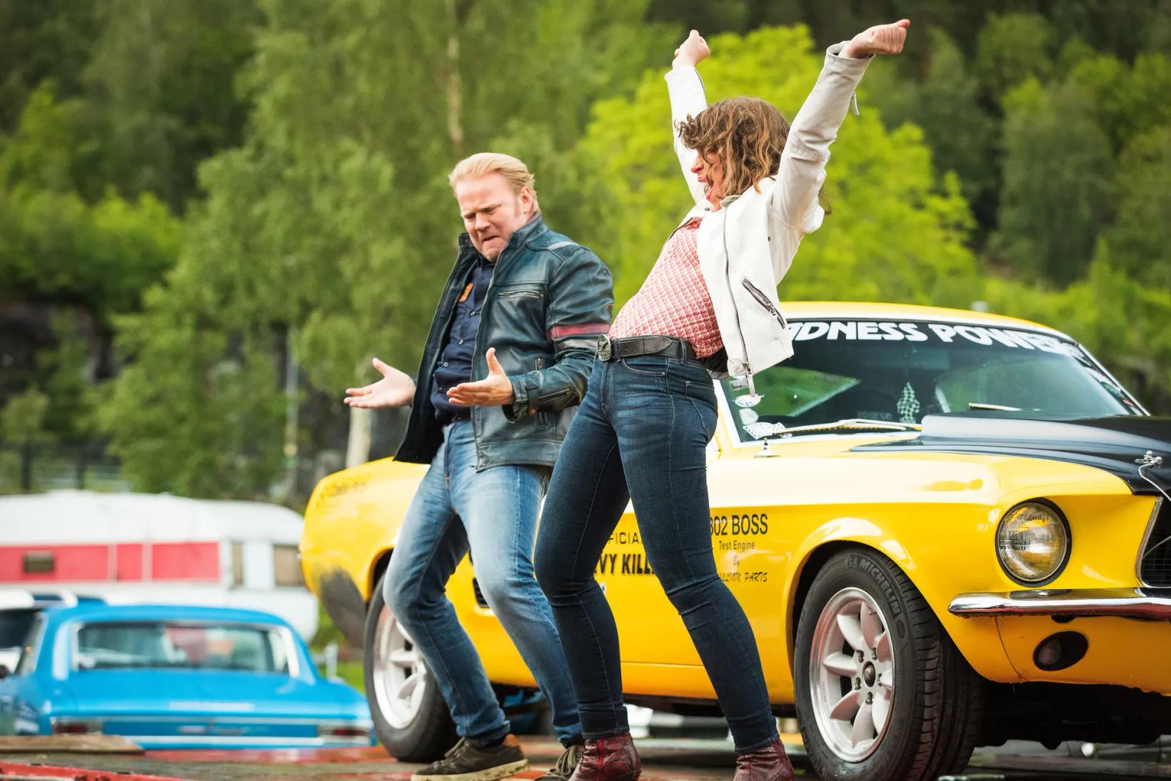 Anders Baasmo Christiansen and woman posing in front of a yellow car
