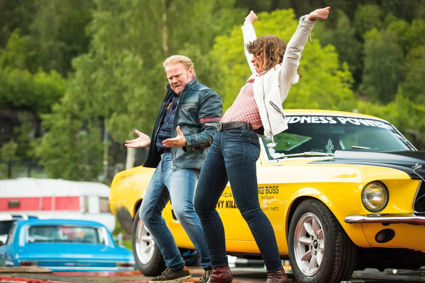 Anders Baasmo Christiansen and woman posing in front of a yellow car