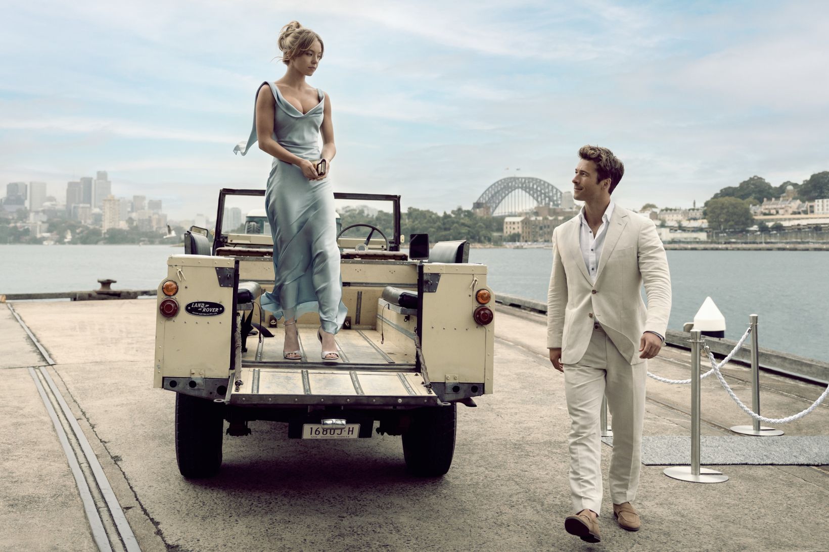 a man and a woman standing on a trailer with a large body of water in the background