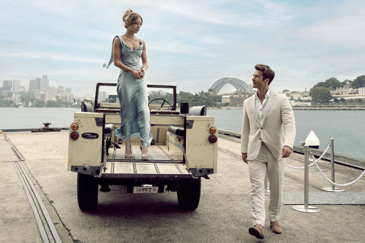 a man and a woman standing on a trailer with a large body of water in the background