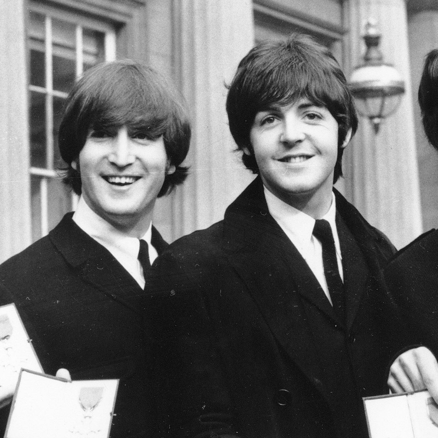 Ringo Starr, John Lennon, Paul McCartney og George Harrison smiler til kamera utenfor Buckingham Palace, England, 26. oktober 1965.