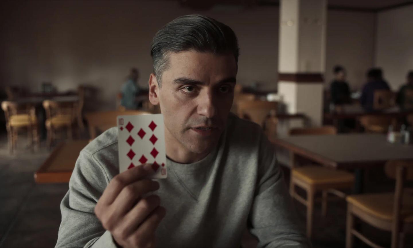 Oscar Isaac holding a card