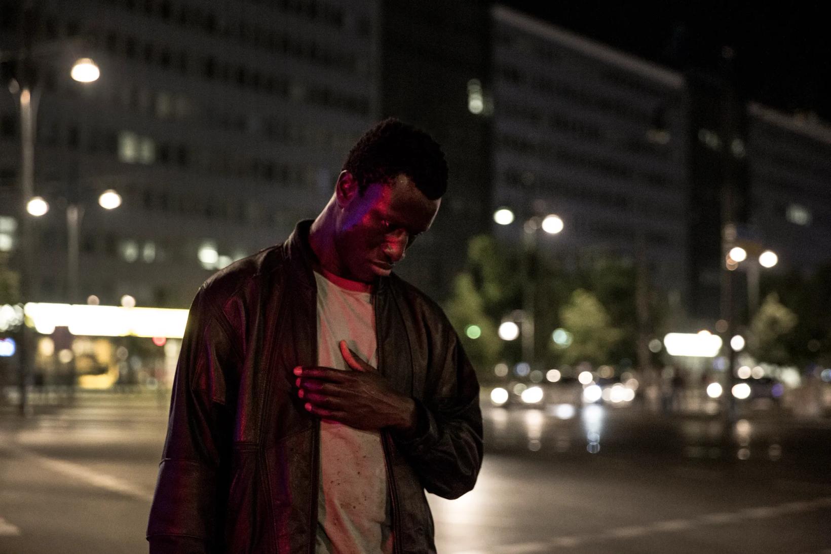 a man standing on a street at night