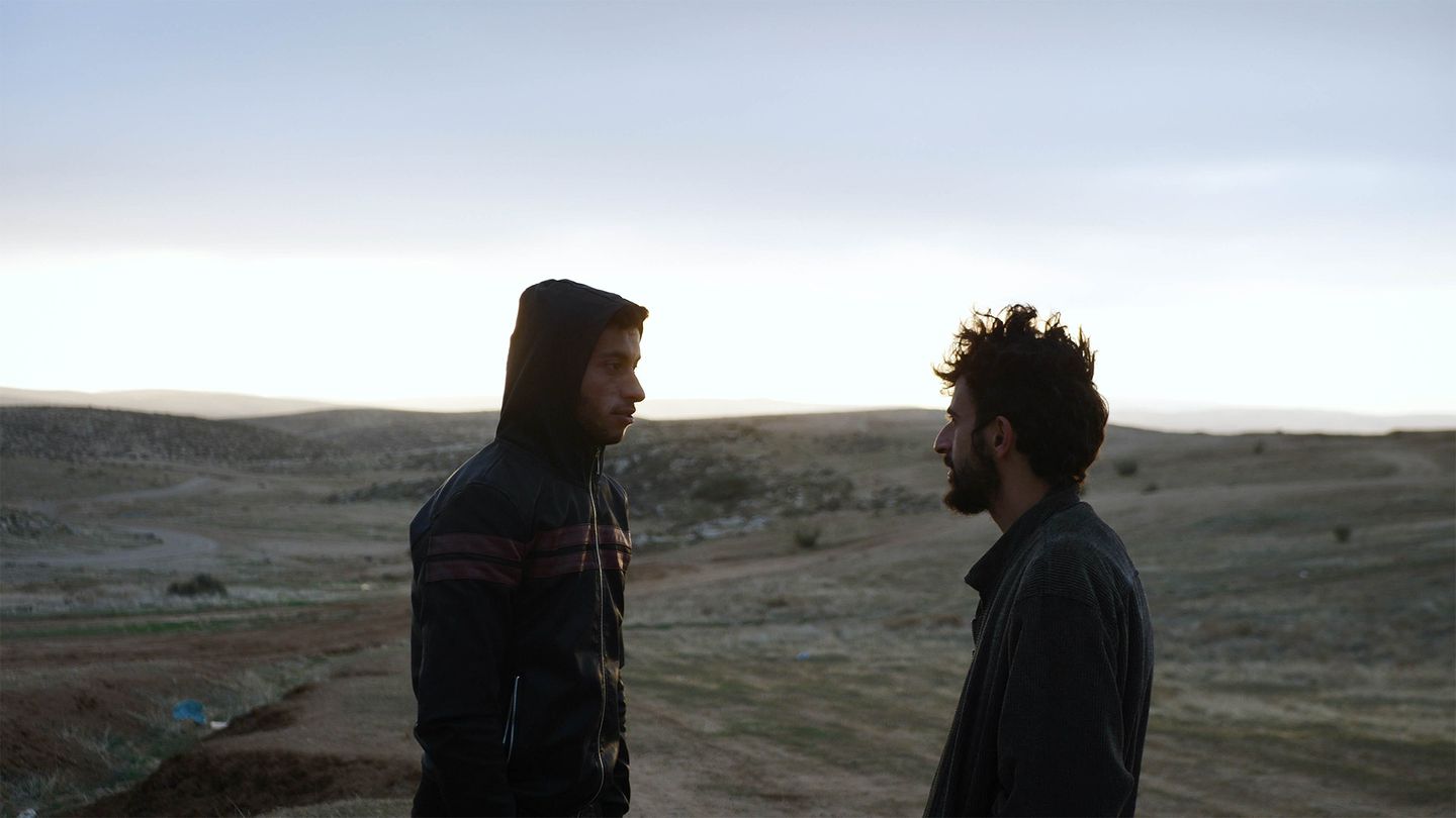 two men standing in a desert