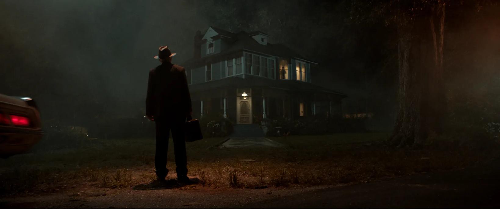 a man standing in front of a house at night