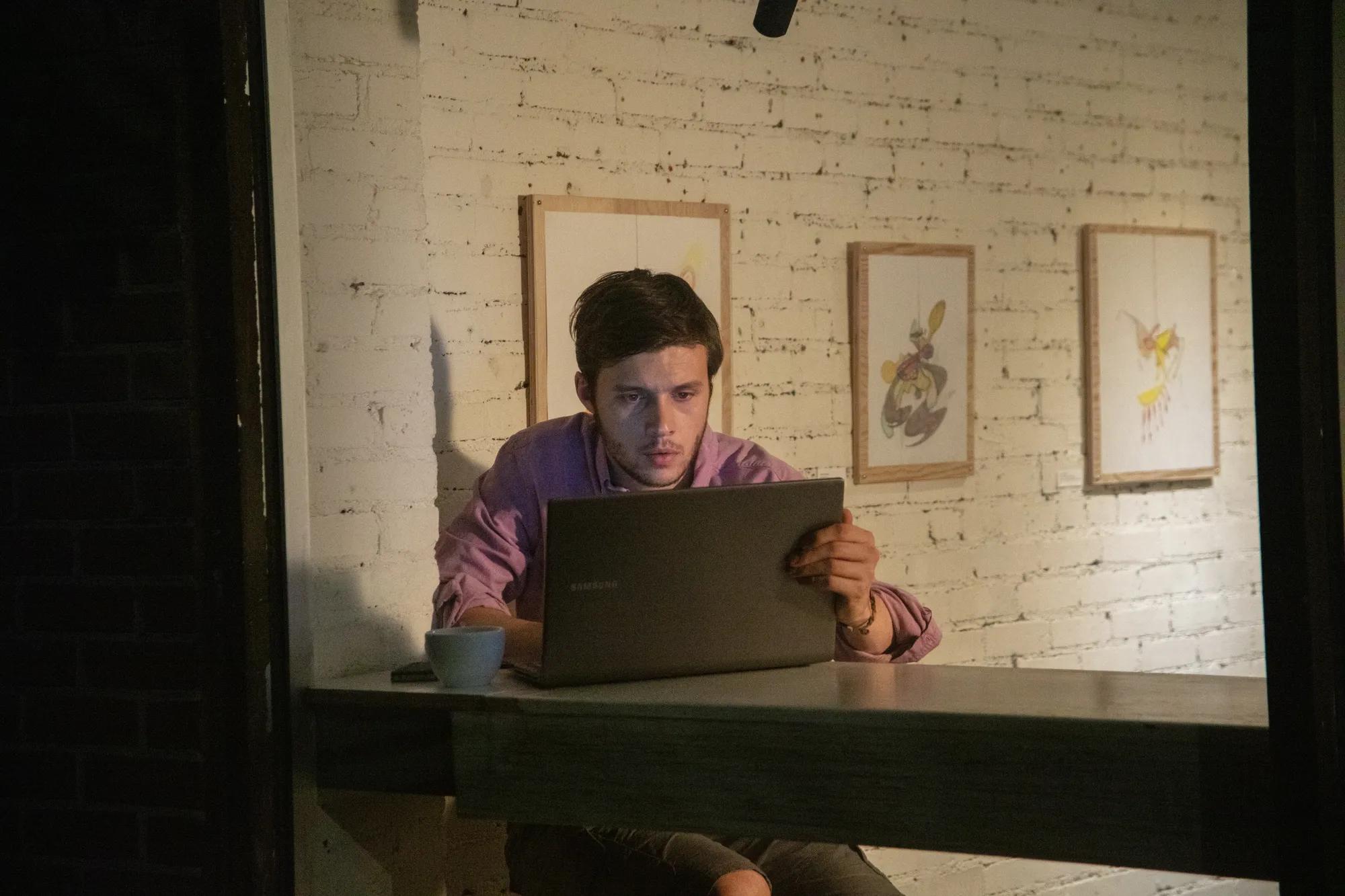 Nick Robinson sitting at a table with a laptop
