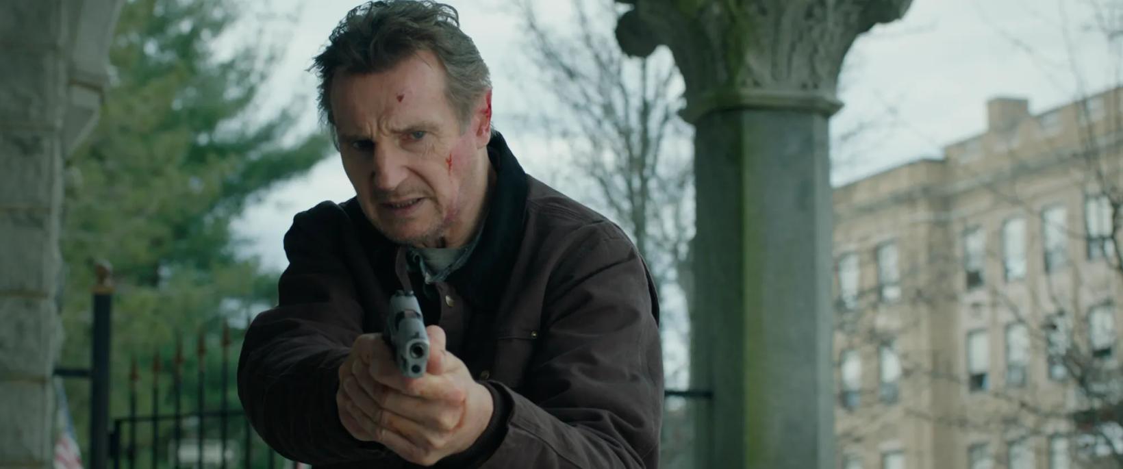 Liam Neeson holding a phone