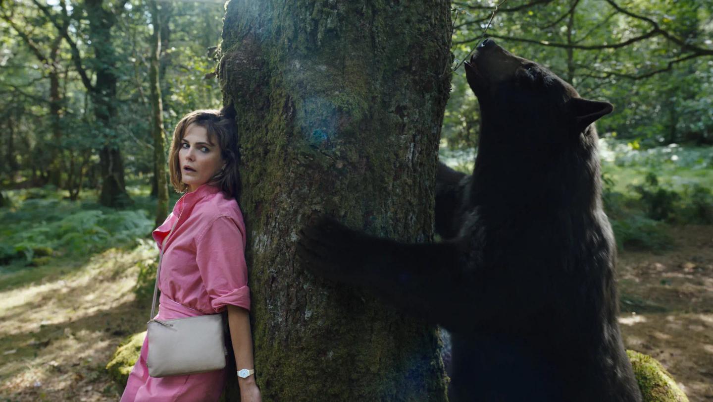 Keri Russell standing next to a bear