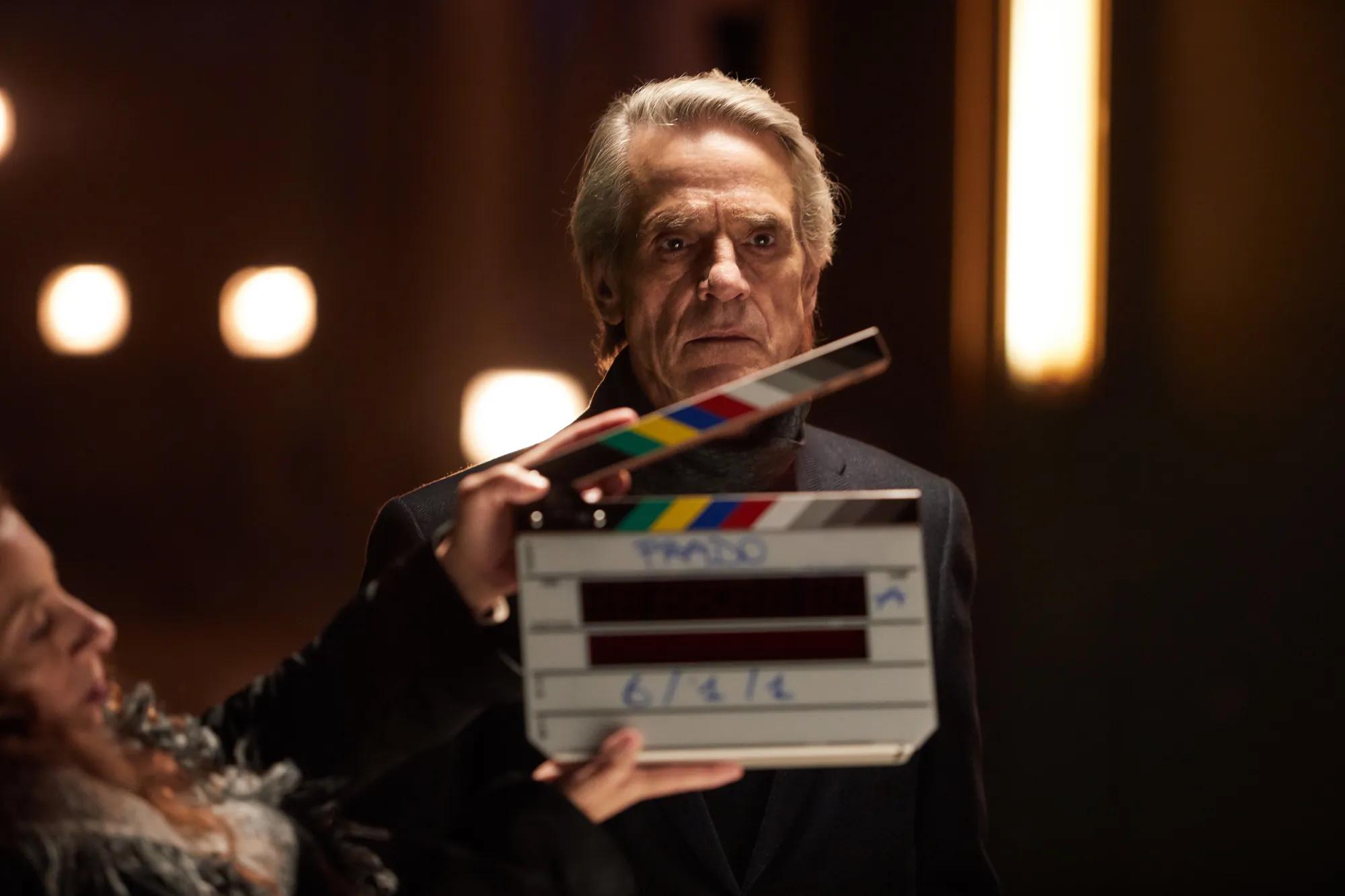 Jeremy Irons holding a box